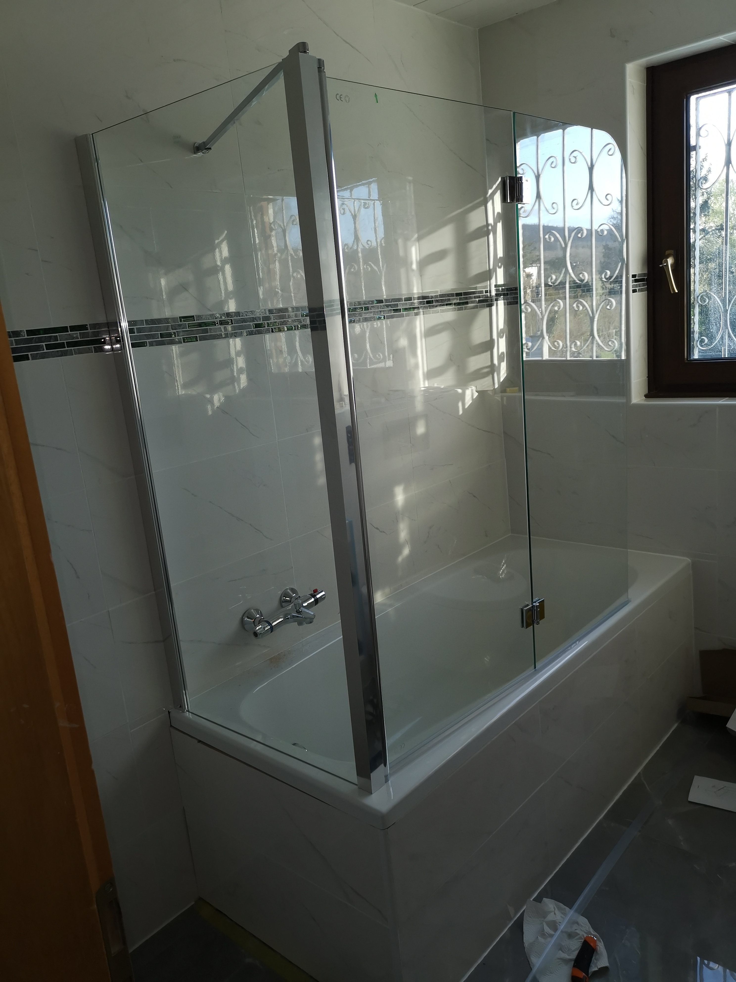 Badezimmer nachher – moderne Glasdusche und helle Fliesen